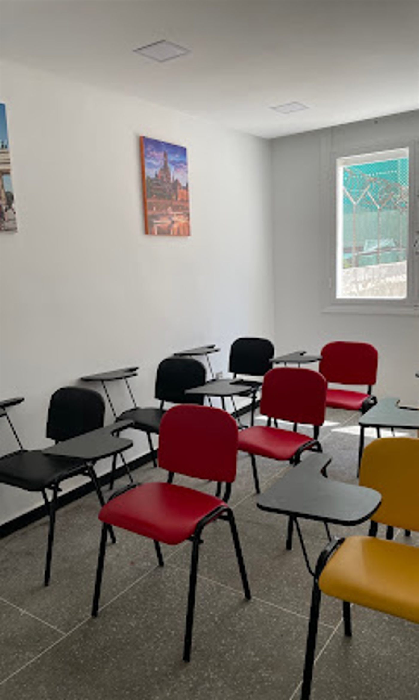 Klassenraum der Sprachschule Almani Visa in Tanger mit Einzeltischen und Motiven deutscher Städte